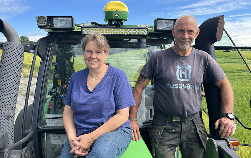 Anine og Roy Henriksen Wollebæk sitter på traktoren som har fått gul kule fra John Deere.