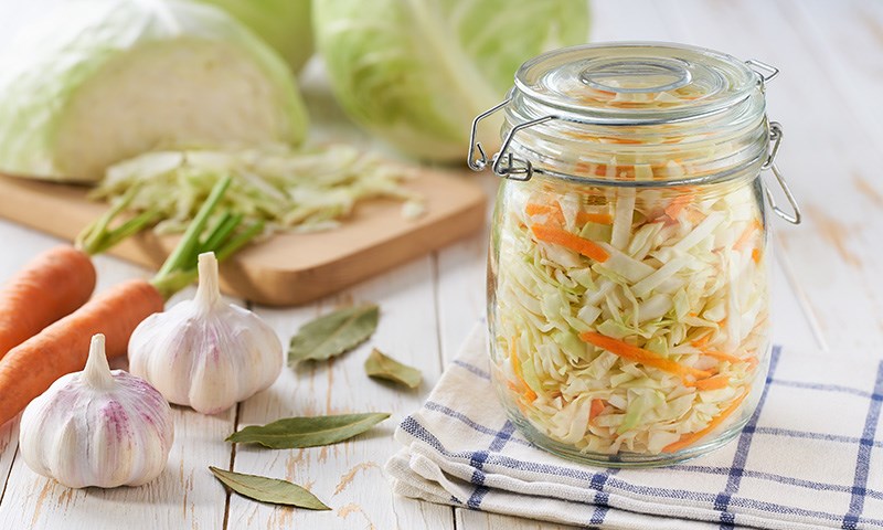 Gulerot, kål og hvitløk i glass på kjøkkenbenk