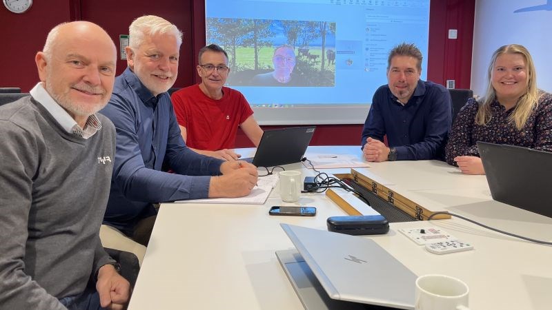 5 personer rundt et bord og en på skjermen