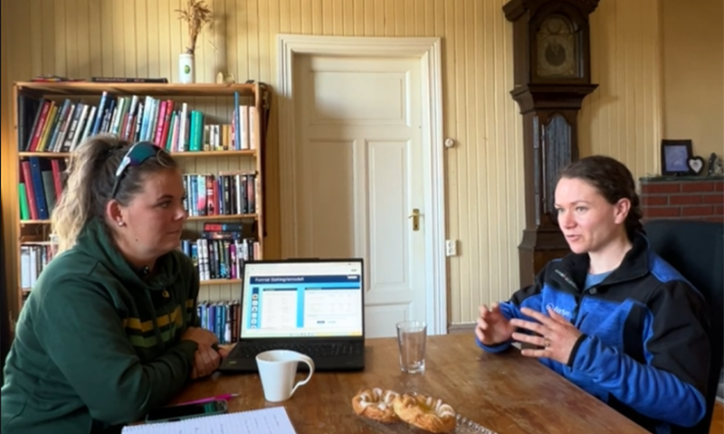 To damer, en dataskjerm og et gulvur