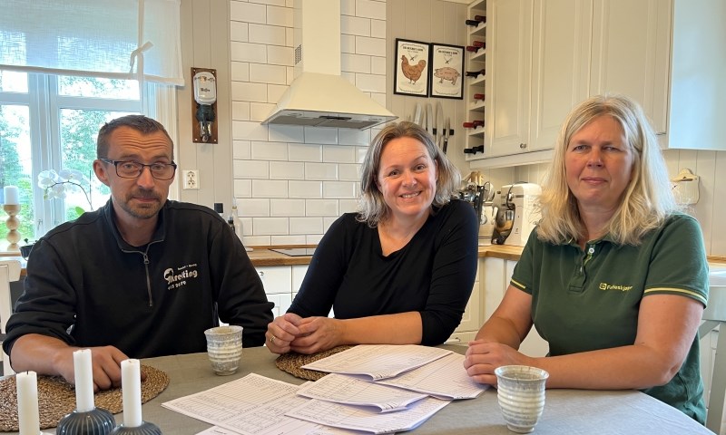 Møte på kjøkkenet med tre personer rundt bordet.