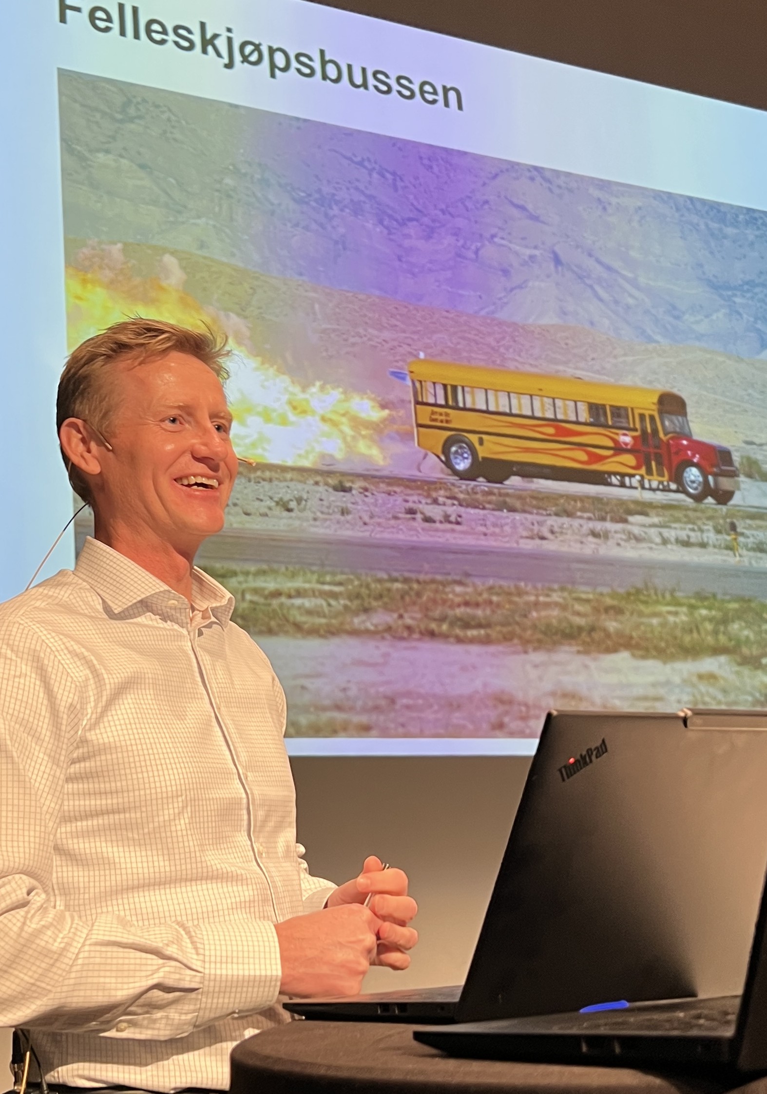 Blid mann foran buss med etterbrenner