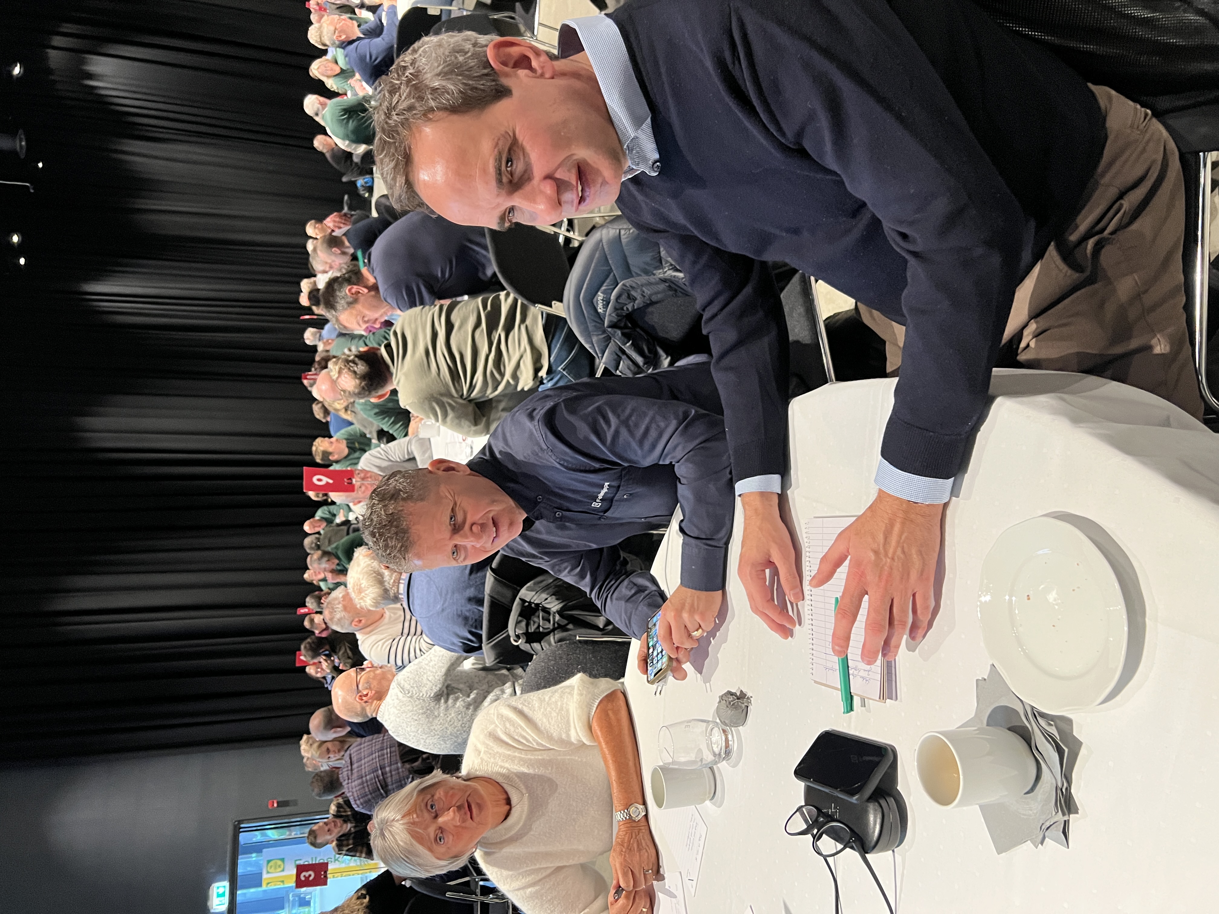 Folk rundt et rundt bord i en konferansesal