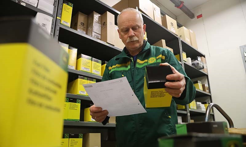 Mann og  traktor i solnedgang