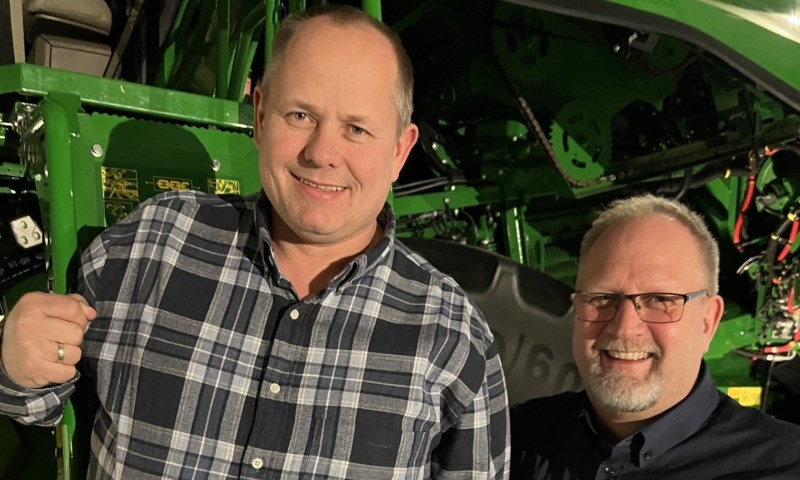 To karer foran en John Deere skurtresker.