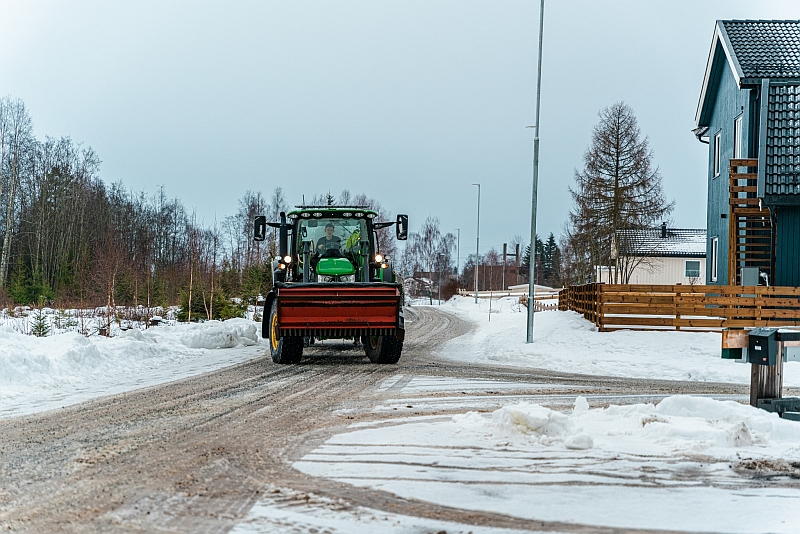John Deere traktor med frontmontert str&oslash;kasse fra Tokvam i boligfelt