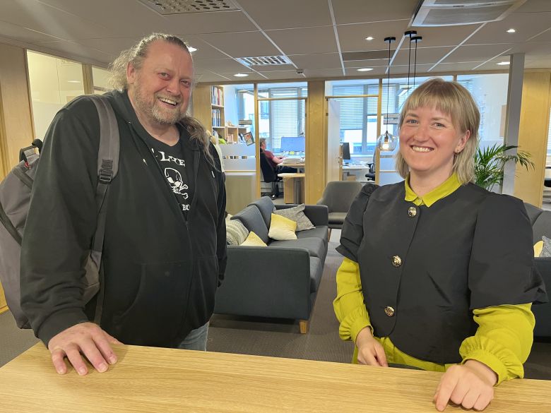 To blide personer i et kontorlandskap