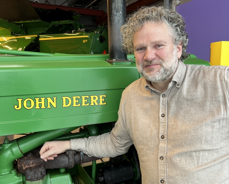 Mann foran traktor og tresker