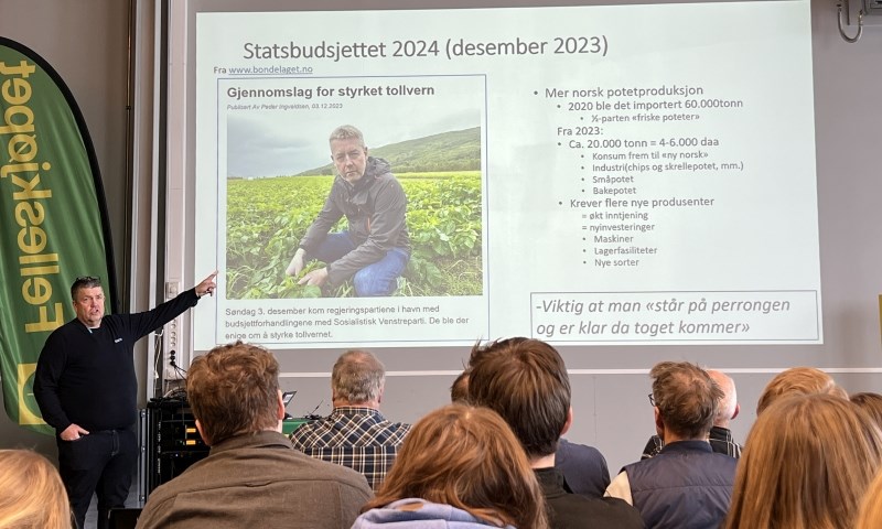 Foredragsholder med plansje foran publikum