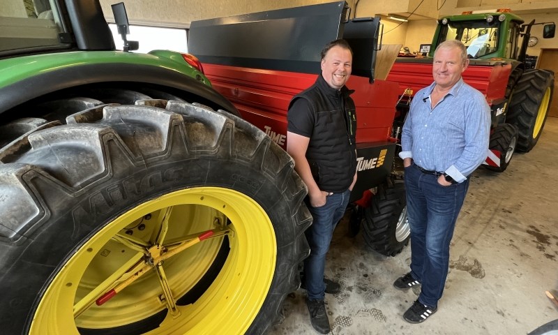 To karer i en maskinhall med to traktorer og to såmaskiner