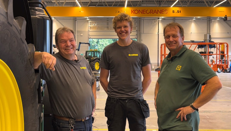 Tre glade karer og en traktor p&aring; et landbruksverksted