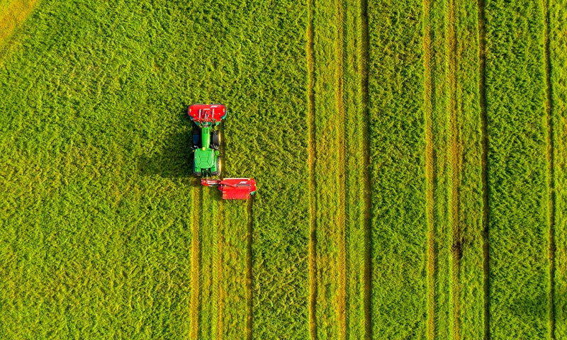 Flyfoto av åker med traktor i arbeid