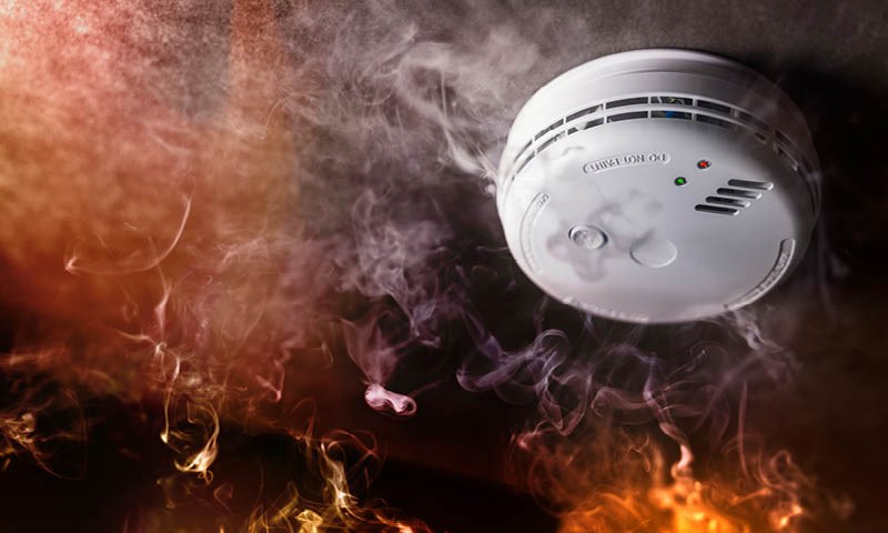 Røykvarsler omgitt av røyk og ild