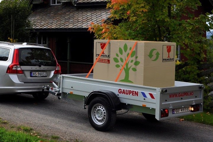 Grå Volvo stasjonsvogn med lastet tilhenger bak